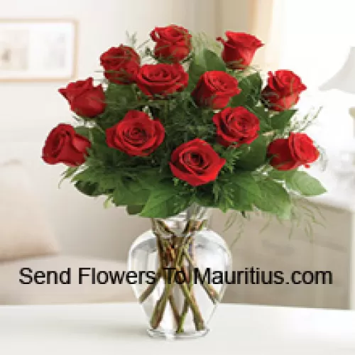 12 rote Rosen mit etwas Farn in einer Glasvase