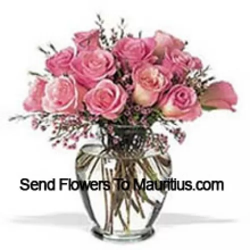 Strauß aus 12 rosa Rosen mit einigen Farnen in einer Vase